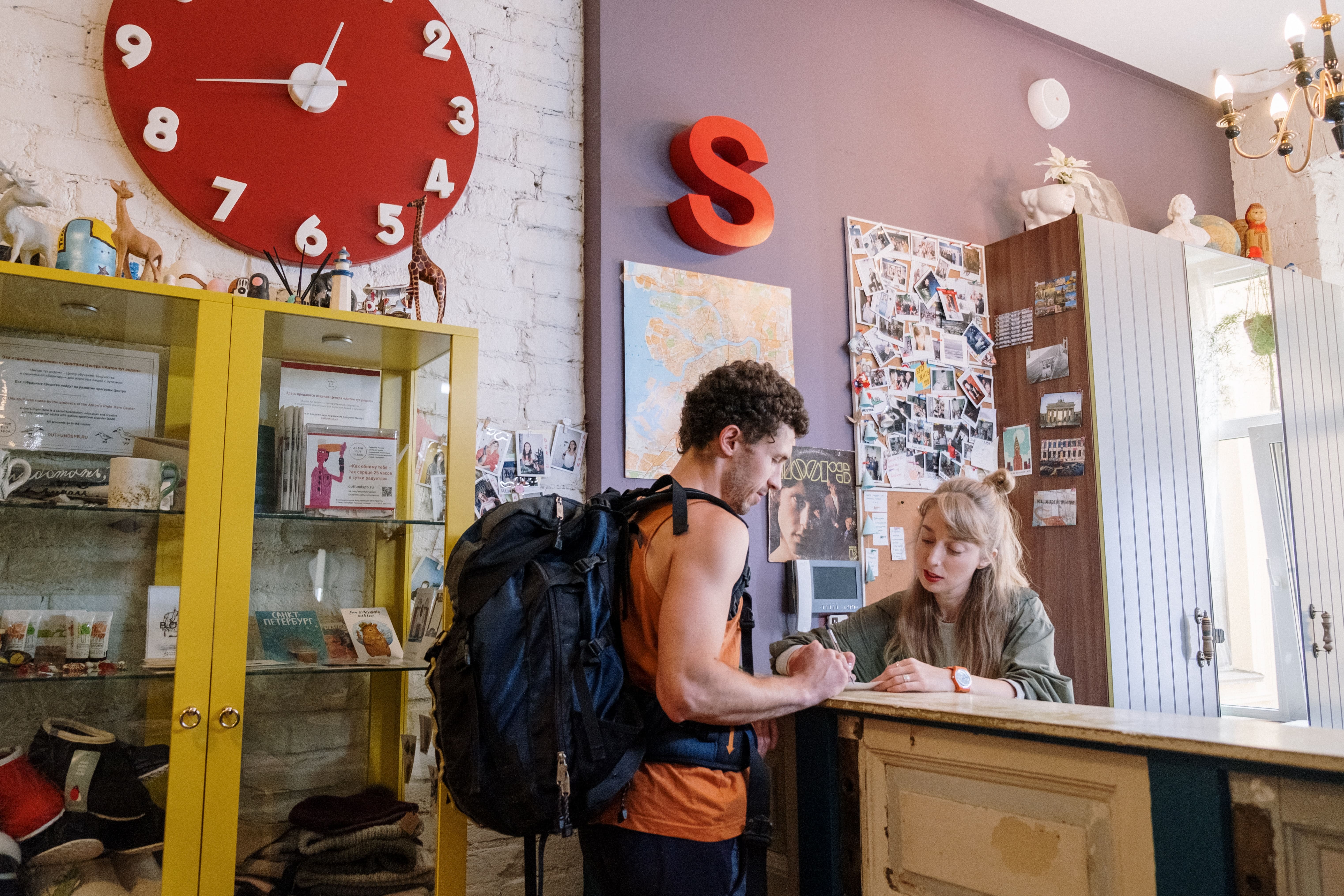 Hostel employee helping a guest at the front desk